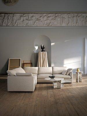 Black Paris table lamp on black Expose side table beside black sofa; Rubble vase on draped pedestal in classic interior.